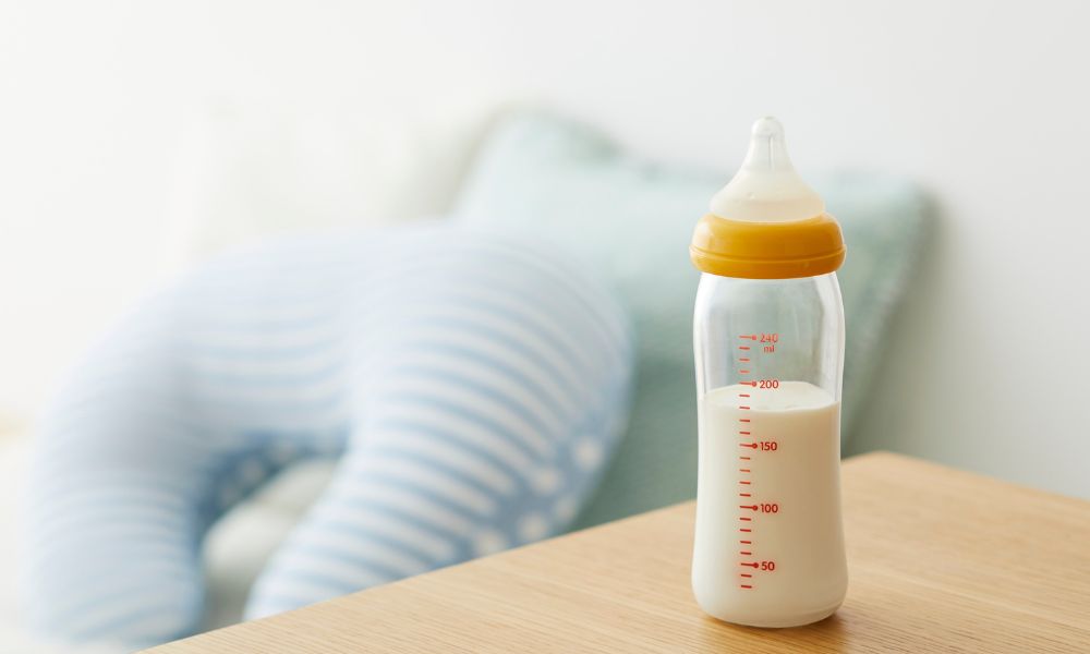 哺乳瓶とクッションから伝わる、ワンオペ育児の孤独な日常イメージ