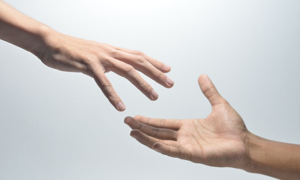 手を差し伸べる2人の手のイメージ